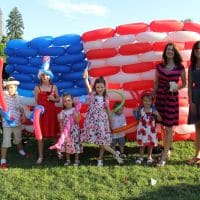 Family with Balloons in front of Balloon Flag
